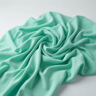 Interlock (Stretch) Wholesale Fabric in Jade/L 6328 - loose-fold fabric view