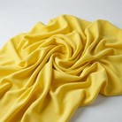 Interlock (Stretch) Wholesale Fabric in Lemon 3559 - loose-fold fabric view