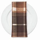 Plaid (Poly Print) in Cinnamon — folded napkin on a white plate