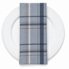 Plaid (Poly Print) in Denim Blue — folded napkin on a white plate