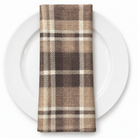 Plaid (Poly Print) in Truffle — folded napkin on a white plate