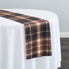 Plaid (Poly Print) in Cinnamon — narrow table runner over a white-covered round table